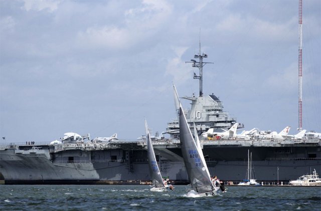 Sailboats race on Charleston Harbor with the USS Yorktown as the backdrop. Photo by Priscilla Parker